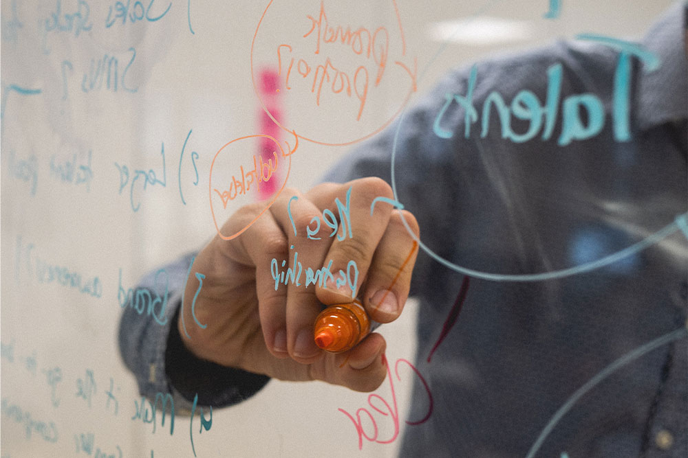 digital marketer brainstorming on a dry erase board